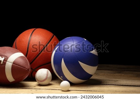 Set of various sport balls on wooden floor on black background