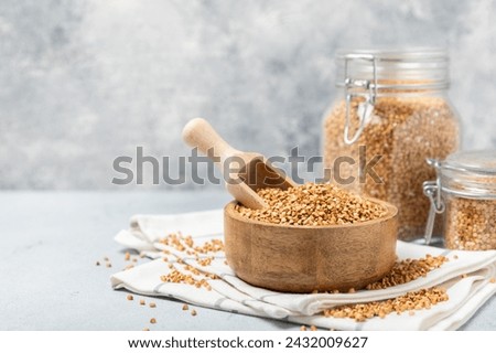 Green buckwheat in a bowl on a wooden kitchen table.Superfood.Raw buckwheat porridge.Healthy vegan food concept, eco products, diet. Copy space.Organic food.weight loss and proper nutrition. Royalty-Free Stock Photo #2432009627