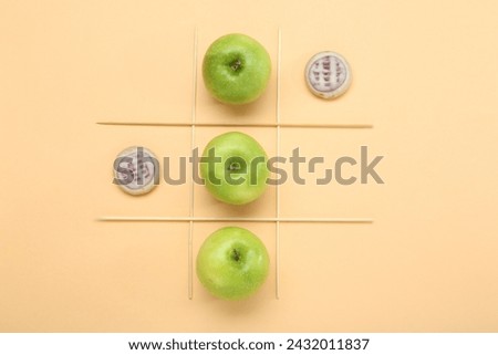 Tic tac toe game made with apples and cookies on beige background, top view