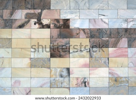 This high-resolution stock photo features a mosaic of natural stone tiles, each with its own unique pattern and palette of colors ranging from earthy tones to delicate pinks and bold streaks.