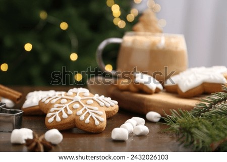 Decorated cookies on table against blurred Christmas lights, closeup