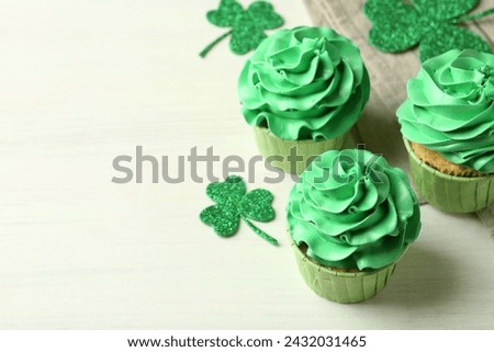 St. Patrick's day party. Tasty cupcakes with green cream on white table, closeup. Space for text