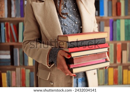 woman holding books on library background, closeup. space for text,education and reading concept,female student holding books