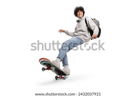 Cool young man with headphones and backpack riding a skateboard isolated on white background     Royalty-Free Stock Photo #2432037921