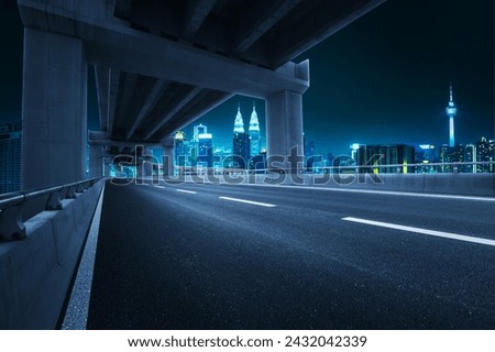 Empty asphalt highway road under overpass and city view. Night scene.