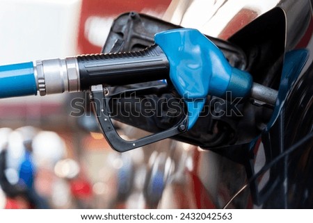 Cropped picture of a fuel nozzle filling a vehicle tank. Car refueling on petrol station. Fuel pump at station. Refueling the car at a gas station fuel pump.