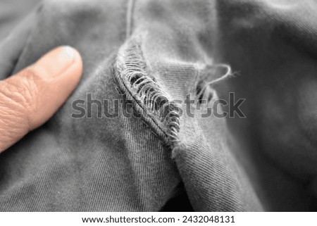 Broken jeans on the back cracked with hole at the crotch. Sewing machine and stitching repair concept.  Royalty-Free Stock Photo #2432048131