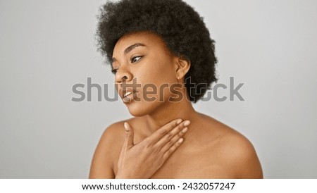 A contemplative african american woman with curly hair poses against a white background, representing beauty and elegance.