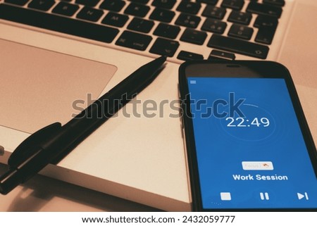 Pomodoro Technique Time Management App. Hands to start the tomato timer on the smartphone screen. Used to improve work Royalty-Free Stock Photo #2432059777