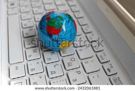 Miniature Globe With A Visible Image Of The USA and Canada Lying On White Desktop Bilingual Keypad 
