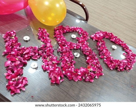 this image of happy birthday write with red rose petals and balloons red and yellow
