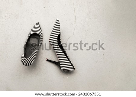 Striped court shoes with traces of wear on a gray concrete floor