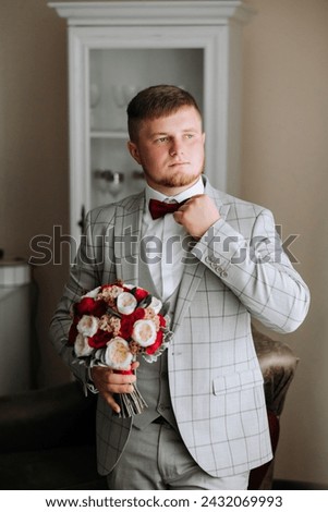 groom with a bouquet of roses, groom with bouquet, groom with a wedding bouquet, a young man with a wedding bouquet on his hand, well suited man