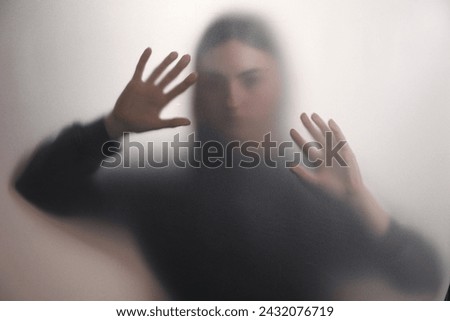 Silhouette of ghost behind fabric against light grey background