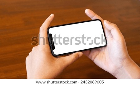 Close-up male office worker or employee using his smartphone at his office desk. smartphone white screen mockup.