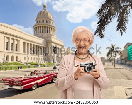 Elderly female tourist with a vintage camera in Havana, Cuba