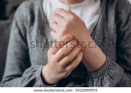 Close up of unhealthy young female massage hand with wrist pain, rheumatoid arthritis. Woman suffer from numbing pain in hand, numbness fingertip, arthritis inflammation, peripheral neuropathies