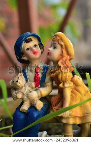 Couple toy sitting on bench in house garden, couple in love and pre-wedding background concept