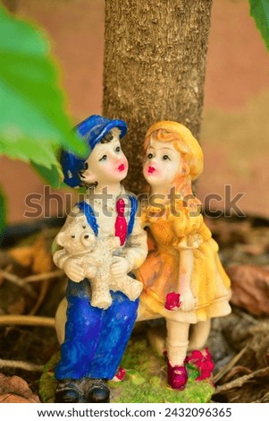 Couple toy sitting on bench in house garden, couple in love and pre-wedding background concept