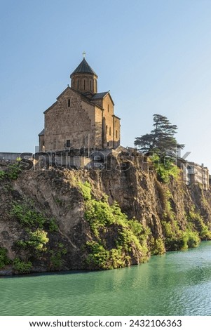 Awesome view of the Virgin Mary Assumption Church of Metekhi on the cliff over the Kura (Mtkvari) River in Tbilisi, Georgia. The Georgian Orthodox Christian church is a popular tourist attraction. Royalty-Free Stock Photo #2432106363