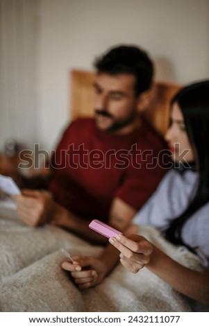 Woman and man reading pregnancy test instructions side by side	