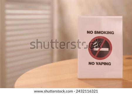 No Smoking sign on wooden table indoors, space for text