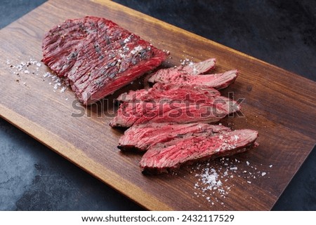 Traditional American barbecue bavette steak with salt and pepper served as close-up on a wooden design board  Royalty-Free Stock Photo #2432117529