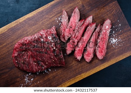 Traditional American barbecue bavette steak with salt and pepper served as top view on a wooden design board Royalty-Free Stock Photo #2432117537