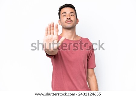 Young handsome man over isolated white background making stop gesture