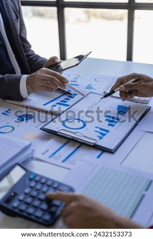 Meeting income charts and graphs with a laptop computer, business analysis and strategy ideas, meeting with business consultants and discussing financial situations in the vertical. Close-up image Royalty-Free Stock Photo #2432153373
