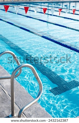 Handrail, Turning T marking under public competitive swimming pool, colorful string of polyester vinyl backstroke flags hanging over swimming lanes pool lane divider rope floats in Dallas, Texas. USA