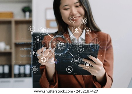 Businesswomen using tablet with laptop and document on desk in modern office with virtual interface graphic icons network diagram.