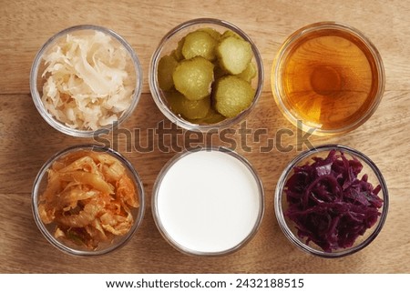 Fermented foods - kim chi, white and purple sauerkraut, apple cider vinegar, kefir and gherkins Royalty-Free Stock Photo #2432188515