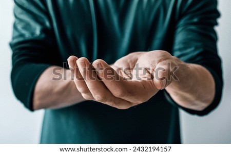 Close-Up of Man's Hand Begging with Palm Up, Intense Emotion, High-Resolution Royalty-Free Stock Photo #2432194157