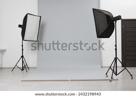Modern light grey photo background and softboxes in studio Royalty-Free Stock Photo #2432198943