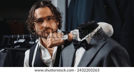 Banner store luxury classic menswear. Tailor man fitting bespoke suit in atelier.