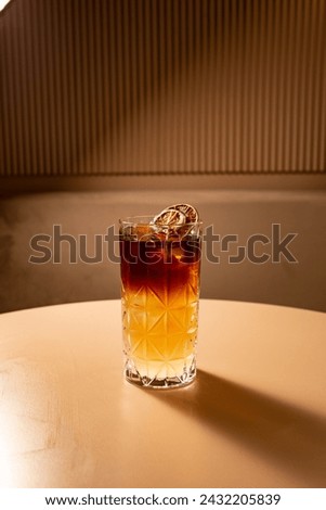 Dark and stormy cocktail with bitter and orange juice and rum