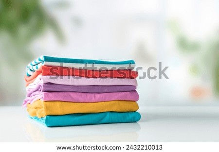Stack of cotton colorful clothes on white table empty copy space.Clothing pile, folded apparel. Royalty-Free Stock Photo #2432210013