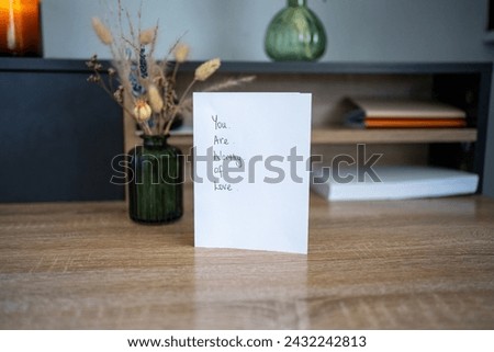 You are worth of love. Handwritten message affirming positively to someone who feels unworthy. Notelet on a desk. Simple design. Kindness and hope for healing mental health.  Royalty-Free Stock Photo #2432242813
