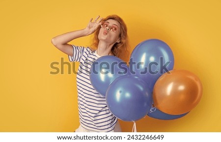 party girl with balloon in sunglasses. positive girl hold party balloons in studio.