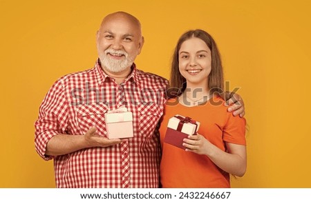 smiling child and granddad with present box for anniversary