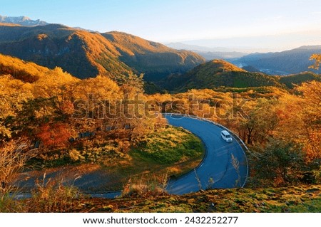 Aerial view above Irohazaka いろは坂, a scenic mountain highway connecting Lake Chuzenji to Nikko City, in Tochigi Prefecture, Japan, with multiple hairpin turns winding through colorful autumn forests Royalty-Free Stock Photo #2432252277