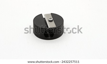 A small black pencil sharpener on a white background.