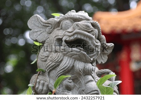 Ancient stone dragon head statue, typical asian fantasy style, with religious ornaments and oriental decorations in taiwanese garden at old spiritual traditional red temple in Taipei, Taiwan, Asia. Royalty-Free Stock Photo #2432257921