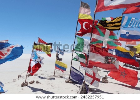 Colorful waving flags from different nations and worldwide states with sign and icons in windy scenic bolivian Salar de Uyuni, white salt flat, tourist landmark attraction in Bolivia, South America.