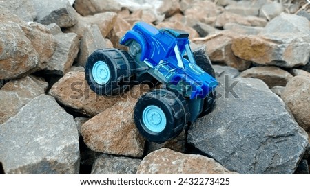 Miniature off-road blue car on up the rock hill