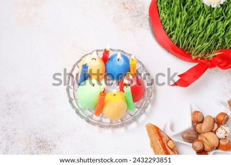 Traditional Azerbaijan holiday Novruz background with green semeni,traditional azerbaijan sweets,shekerbura,qogal,paxlava,mutaki and different nuts and sweets,top view,space for copy.