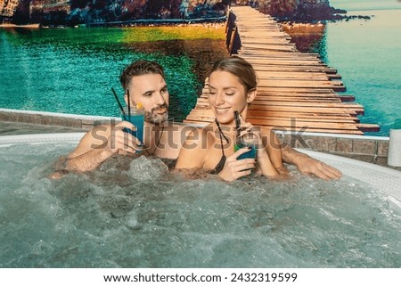 Romantic couple relaxing in the swimming pool drinking cocktails