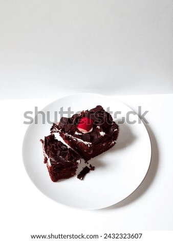 close-up of a piece of delicious and soft black Forest cake on a white plate isolated on white background