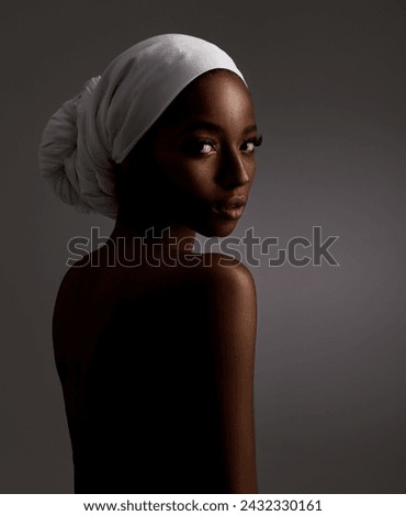 Portrait, beauty and culture with natural black woman in studio on gray background for wellness. Skincare, heritage and tradition with back of young person in headwear for cosmetics or dermatology Royalty-Free Stock Photo #2432330161